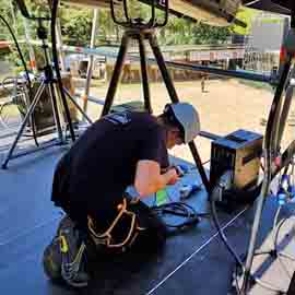 T�cnico operario electricista en la instalaci�n de cableado para concierto.